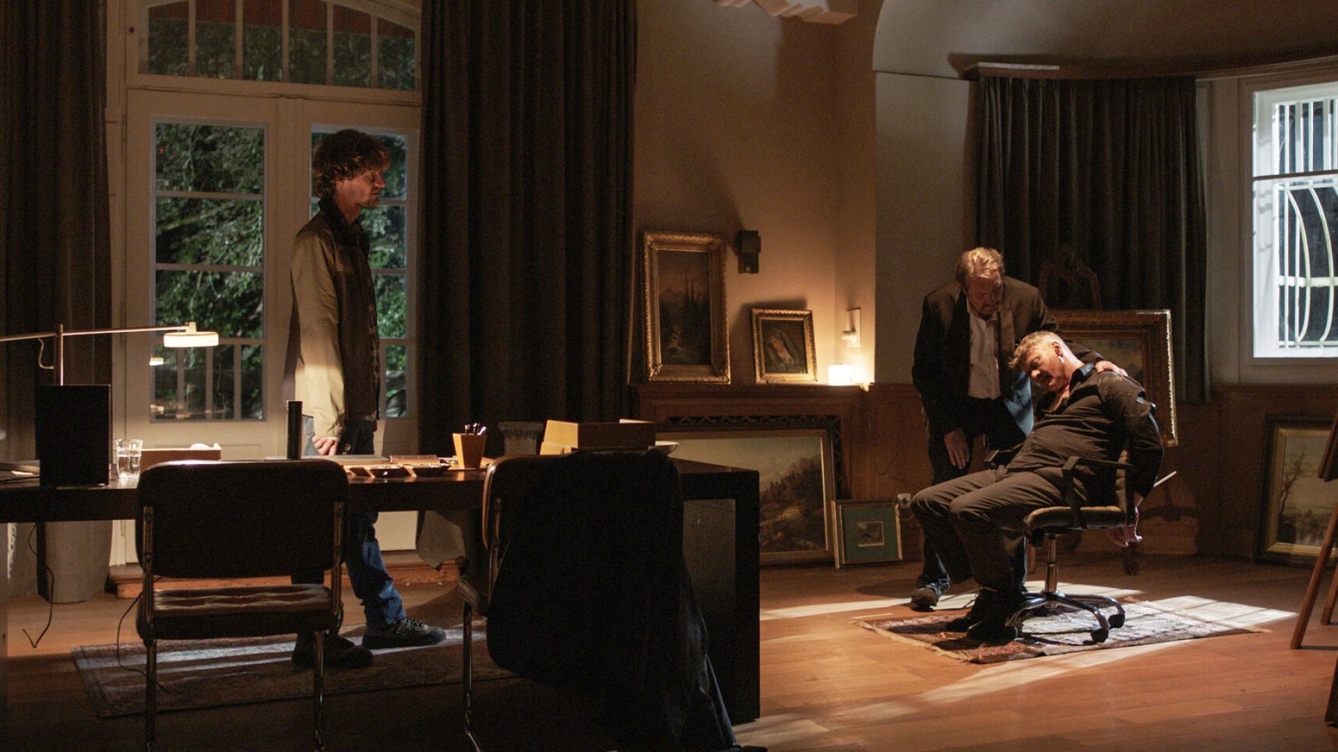 Anton Hauser (Paul Wellenhof, links) und Benedikt Beissl (Andreas Giebel, Mitte) müssen nun schnell handeln, als sie den schwer verletzten Dr. Holger Stalz (Marcus Mittermeier, rechts) in seiner Kunstgalerie auffinden.